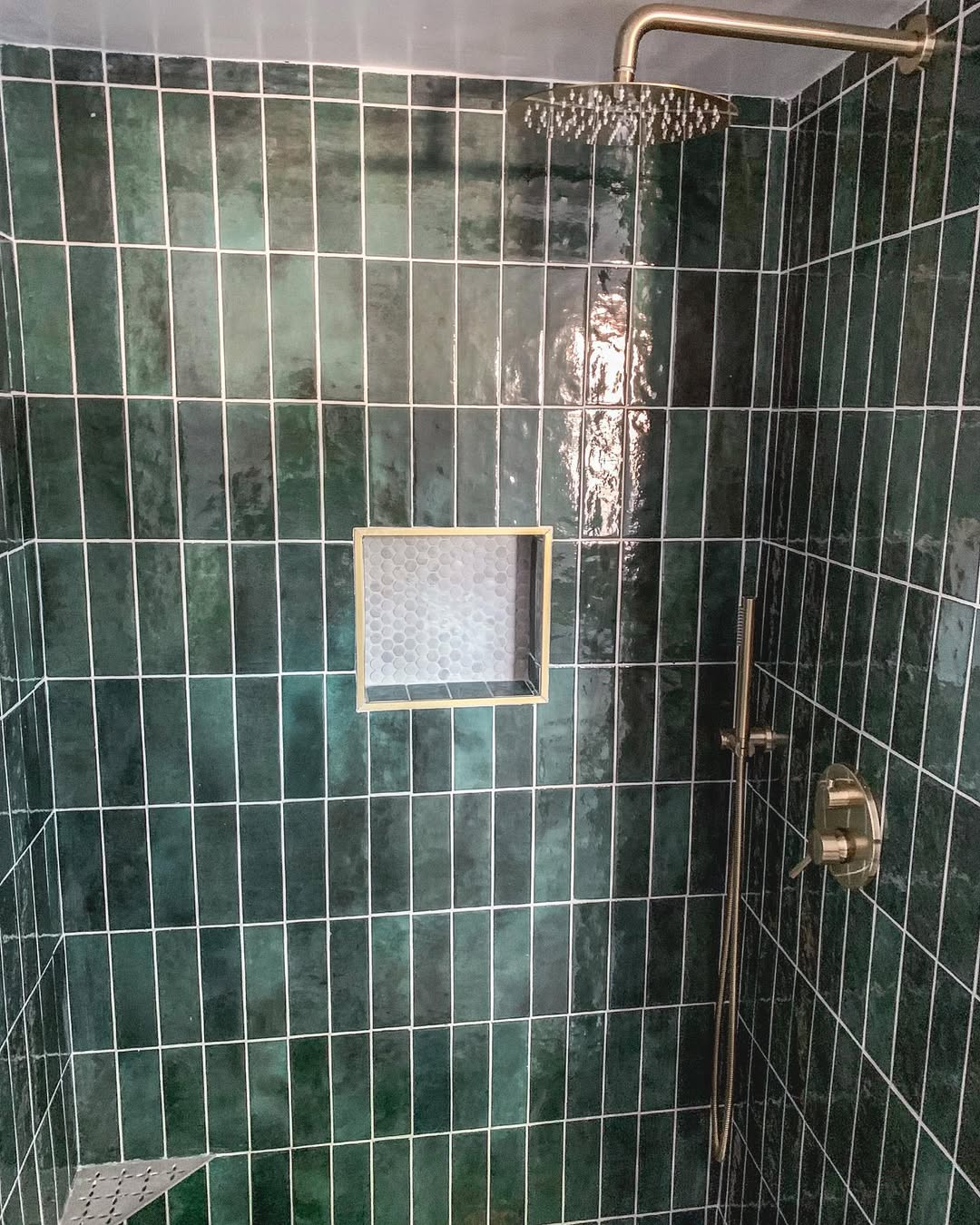 Green tile shower with brass fixtures